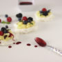 Mini pavlove con crema pasticcera, coulis e frutti di bosco